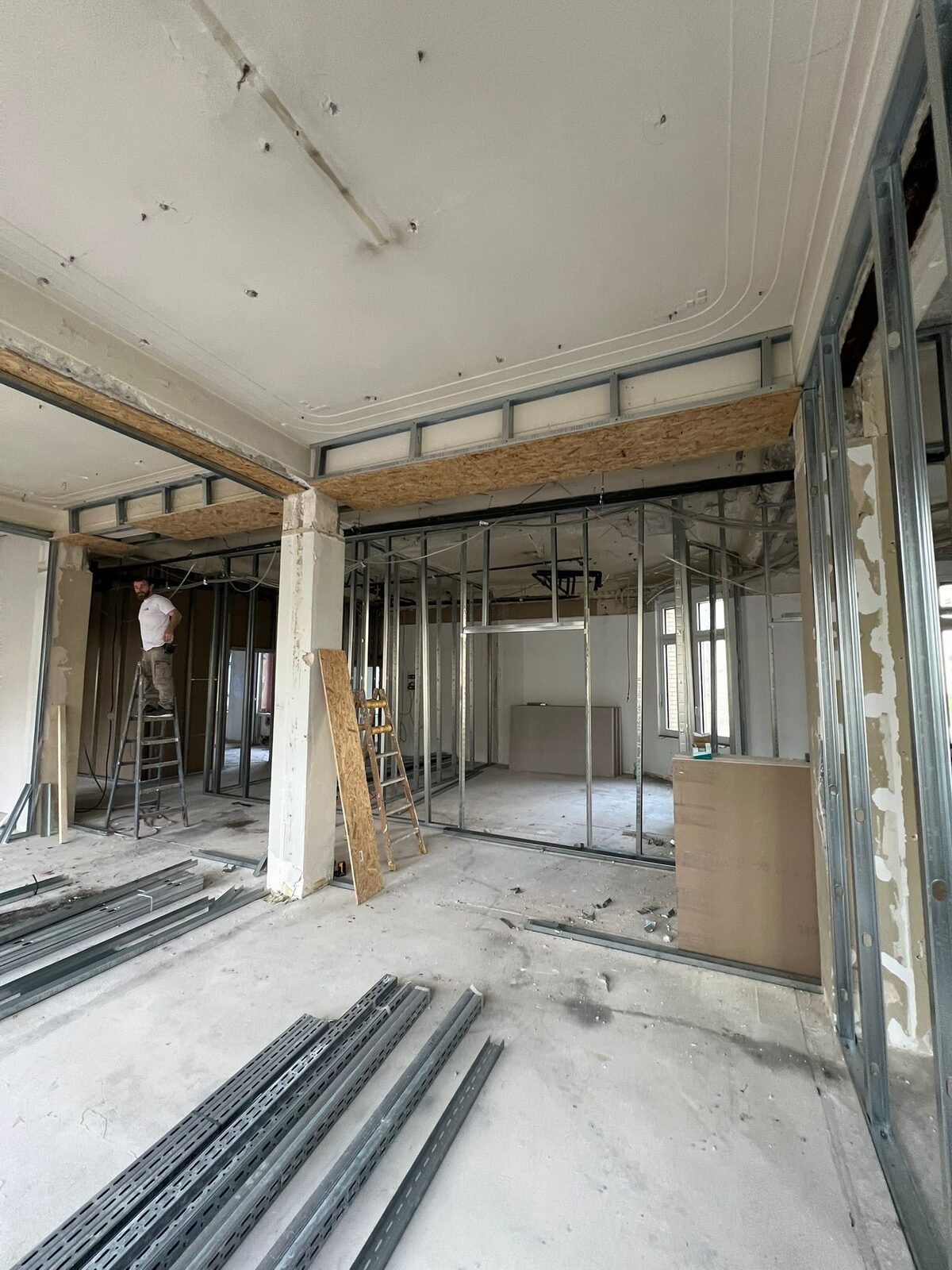 Trockenbau Büroetage – Monteur auf Leiter, Ständerwerk