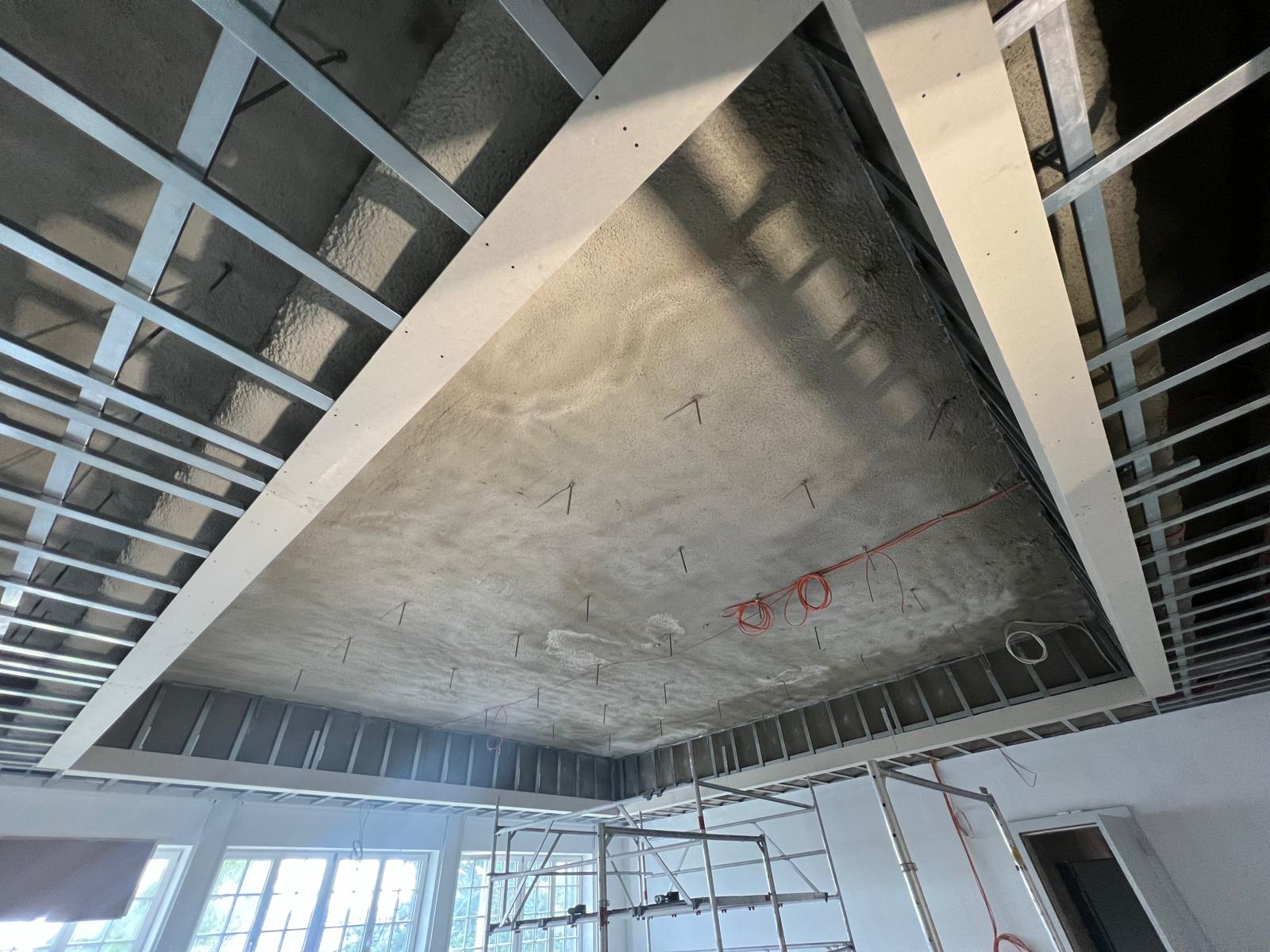 Schule Kempen – Großer Raum mit fertiger Akustikdecke und Gerüst