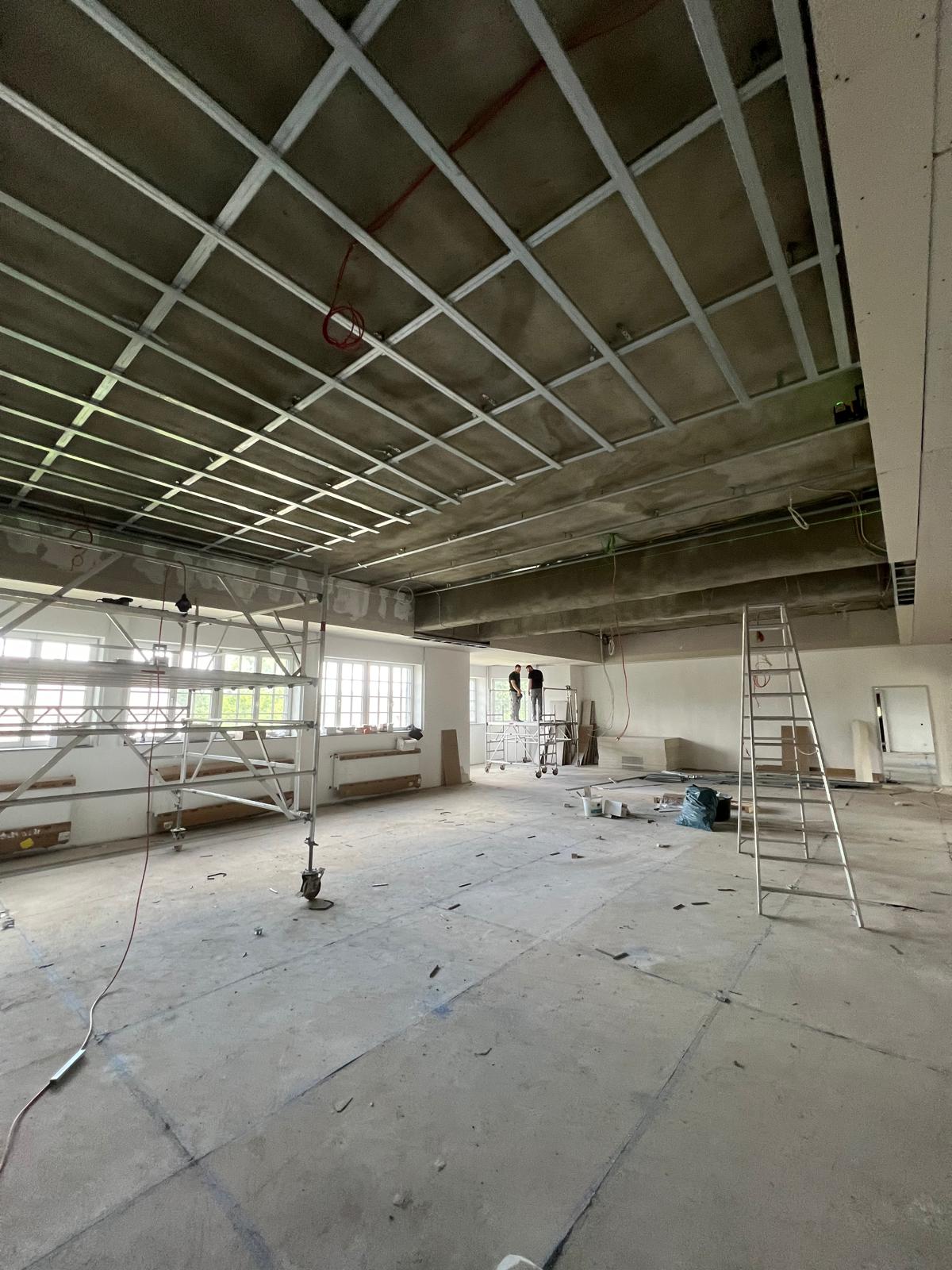 Schule Kempen – Rohdecke mit Abhängern und Arbeiter mit Profilen